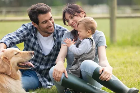 family playing with dog outside